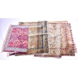 A collection of four silk and part-silk small carpets of Eastern origin nicely decorated in the