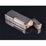 A Dunhill silver plated cigarette lighter with bark effect body and flip up top.