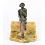 An Art Deco spelter and green onyx smoker's companion set depicting a seated beauty, cigarette in