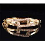 A yellow metal and cubic zirconia set bangle of angular openwork design, stamped 585, interior