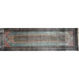 A Persian handwoven part silk runner with elongated central lozenge depicting stylised repeating