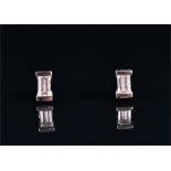 A pair of diamond ear studs (mounts test as gold) each with a baguette-cut diamond of