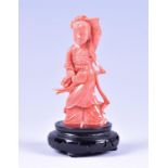 A 19th century Chinese carved coral figure of a woman on a later hardwood stand, 13 cm high (with