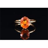 An 18ct yellow gold and Mexican fire opal ring set with a faceted oval-cut opal, approximately 10