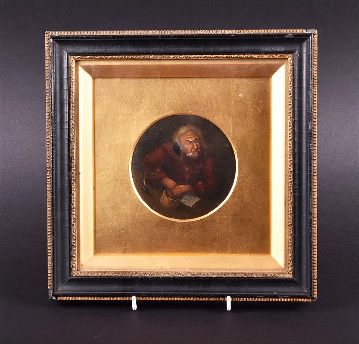 An 18th century circular portrait miniature  depicting a smartly dressed man seated at a writing