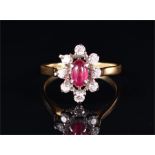 An unusual 18ct yellow gold, diamond, and ruby ring the openwork cluster set with an oval cabochon