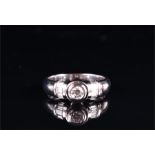 An 18ct white gold and diamond ring collet-set with a round brilliant-cut diamond of approximately
