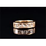 An 18ct yellow gold and diamond ring channel-set with five princess cut diamonds of approximately