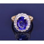 An 18ct yellow gold, diamond, and tanzanite ring set with a mixed oval-cut tanzanite, the