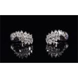 A pair of white gold and diamond earrings each set with thirteen marquise-cut diamonds, with clip