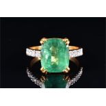 An emerald and diamond ring set with a rectangular cushion-cut emerald of approximately 6.50 carats,