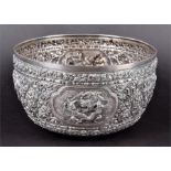 A large Burmese silver bowl decorated with vignettes of warriors and figures between scrolling