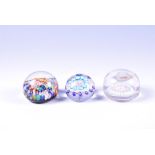 Three small millefiori glass paperweights  to include a footed example with white banded external