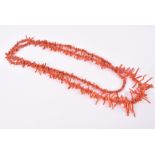 An opera length coral necklace of naturalistic-shaped beads and twigs.
