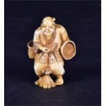 A 19th century Japanese ivory netsuke a figure stands holding woven baskets, in traditional dress