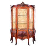 A late 19th century French Louis XV style kingwood vitrine serpentine fronted with scrolled ormolu