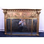 A large gilt overmantle triptych mirror   with Corinthian style columns flanking a relief decoration