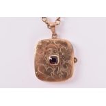 A 9ct yellow gold and garnet locket of square form, with engraved decoration, opening to reveal