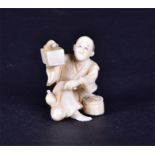 A 19th century Japanese ivory netsuke  in the form of a seated figure holding aloft a tortoise, 4 cm