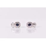 A pair of diamond and sapphire earrings the mounts slightly curved, set with an oval-cut sapphire