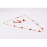A 9ct yellow gold and coral necklace suspended several round coral beads on a fine link chain,