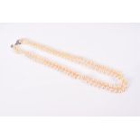 A double strand pearl necklace the white metal clasp set with three diamonds, pearls approximately