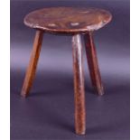 An 18th century or earlier English milking stool  sycamore topped on oak legs, one turned, the
