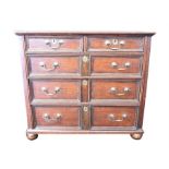 An 18th century oak chest of drawers the top with moulded rim over two short and three long panelled