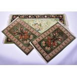 A Chinese silk rectangular rug the central field with foliate decoration on a green ground within