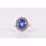 An 18ct white gold, diamond, and sapphire ring set with a mixed oval-cut sapphire of approximately