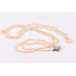 A natural saltwater pearl necklace opera-length, fastening with a French white gold, diamond, and