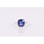 An 18ct white gold, diamond, and sapphire ring set with a cushion-cut sapphire of approximately 3.10