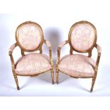 A pair of French carved and gilded salon armchairs with needlework upholstered back, seat and