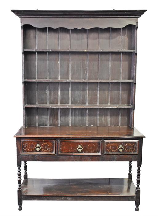 A late 18th / early 19th century oak dresser the top with shaped frieze over three shelves with
