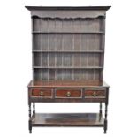 A late 18th / early 19th century oak dresser the top with shaped frieze over three shelves with