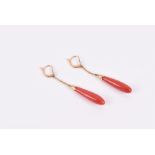 A pair of yellow metal and coral drop earrings each with a tapered coral drop, clasps with
