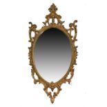 A French style gilt wall mirror of oval form the frame with symmetrical rococo swags, 130 cm x 66 cm