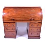 A Victorian mahogany roll top pedestal desk the cylinder slide opening to reveal drawers and