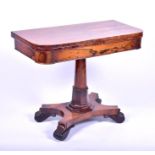 A Regency period rosewood card table opening to reveal a circular inlaid felt surface, designed with