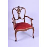 An Edwardian inlaid rosewood armchair designed with Sheraton style backing inlaid with scrolled