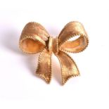 An 18ct yellow gold bow brooch of textured form with beaded borders. CONDITION REPORT 14.3 grams