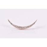 A diamond set crescent-shaped brooch set with nineteen old-cut diamonds, largest central diamond