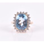 An 18ct yellow gold, diamond, and blue topaz ring set with a large faceted blue topaz, surrounded