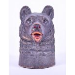 A Black Forest bear tobacco jar fitted with music box realistically carved with glass eyes, the head