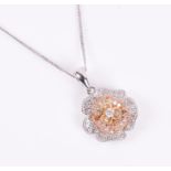An 18ct white, yellow, and rose gold and diamond pendant in the form of a flower, suspended on an