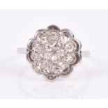 A white metal and diamond floral cluster ring the grouped stones of approximately 0.40 carats