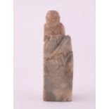 A Chinese carved soapstone seal carved with a single seated figure, bearing old label to base '