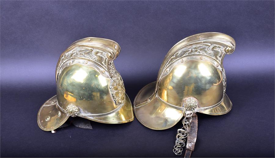 A set of two late 19th/early 20th century Merryweather & Sons brass fireman helmets each mounted