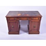 A late Victorian mahogany pedestal desk inlaid with a green tooled leather scriber, over three