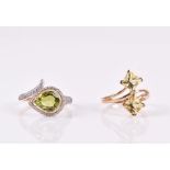 A 9ct yellow gold and peridot ring of stylised snake design, set with a pear-cut peridot and white
